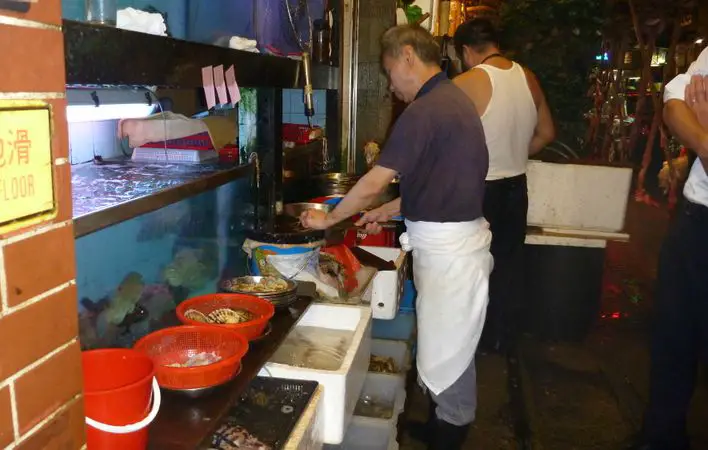 Seafood tanks and cooks at street food stalls